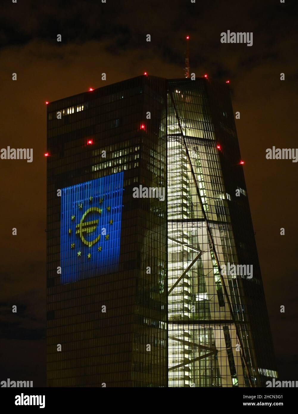 30 décembre 2021, Hessen, Francfort-sur-le-main : lors d'un essai, le symbole de l'euro est projeté sur la façade sud du siège de la Banque centrale européenne (BCE) dans l'est de Francfort.Il y a 20 ans, à la Saint-Sylvestre, la monnaie européenne commune, l'euro, a été introduite dans douze pays de l'UE.Pour l'Allemagne, cela signifiait dire Au revoir au D-Mark.Du 31 décembre 2021 au 9 janvier 2022, la façade de la BCE sera illuminée dans la soirée.Photo: Arne Dedert/dpa Banque D'Images