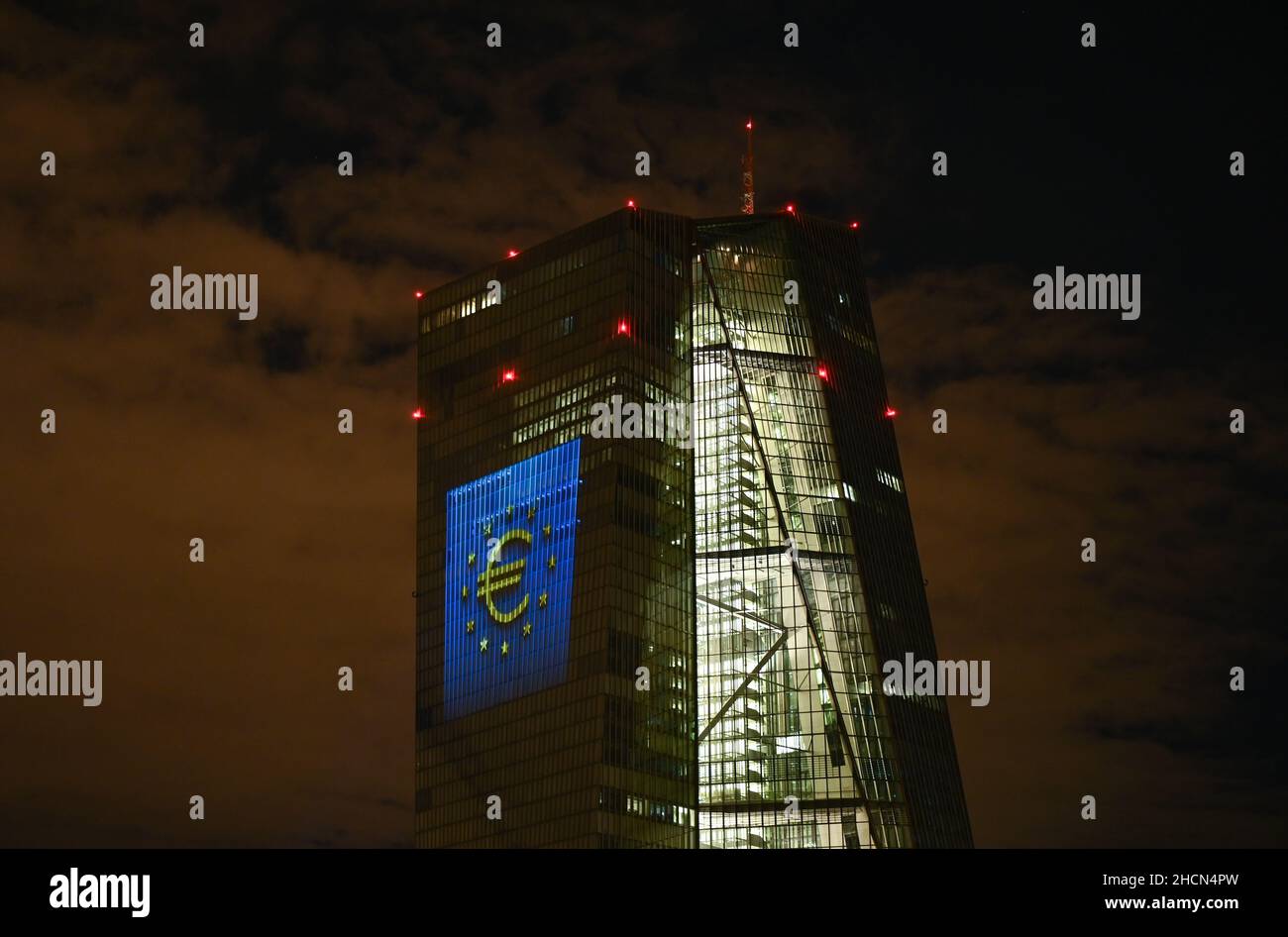 30 décembre 2021, Hessen, Francfort-sur-le-main : lors d'un essai, le symbole de l'euro est projeté sur la façade sud du siège de la Banque centrale européenne (BCE) dans l'est de Francfort.Il y a 20 ans, à la Saint-Sylvestre, la monnaie européenne commune, l'euro, a été introduite dans douze pays de l'UE.Pour l'Allemagne, cela signifiait dire Au revoir au D-Mark.Du 31 décembre 2021 au 9 janvier 2022, la façade de la BCE sera illuminée dans la soirée.Photo: Arne Dedert/dpa Banque D'Images