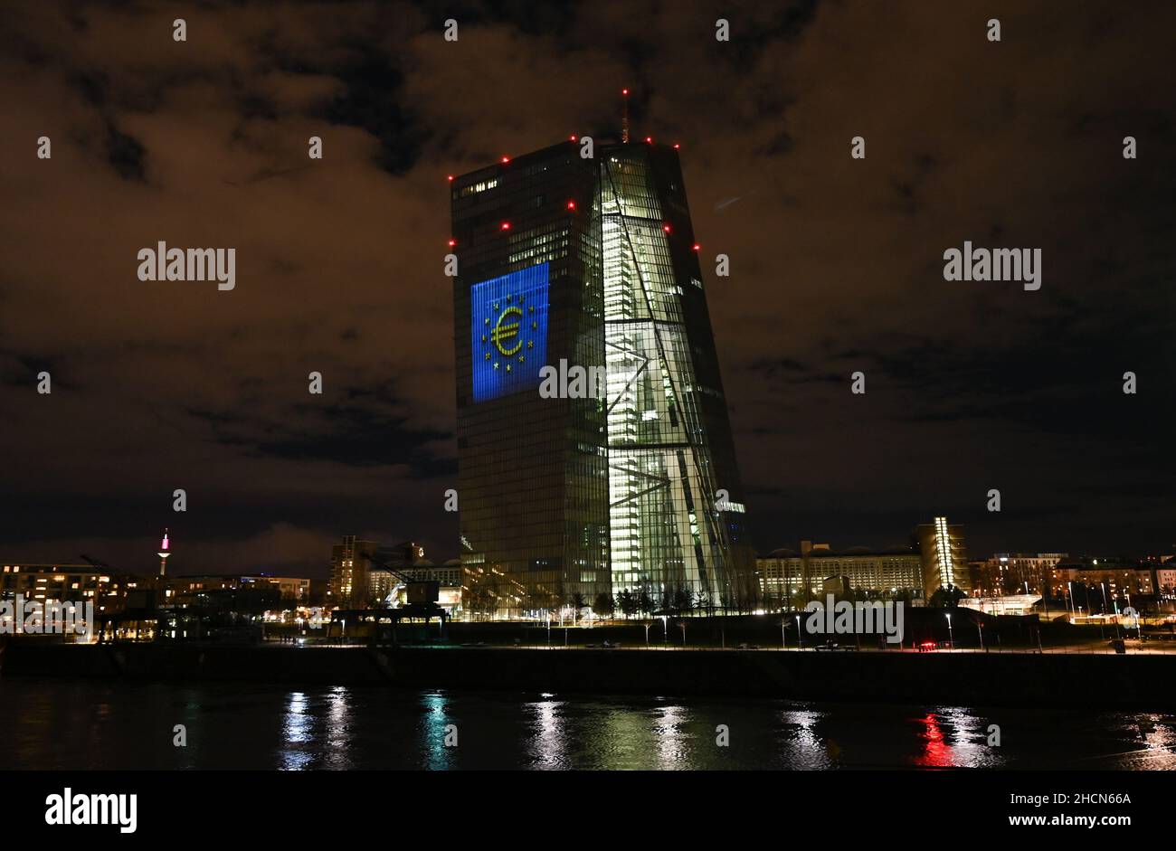 30 décembre 2021, Hessen, Francfort-sur-le-main : lors d'un essai, le symbole de l'euro est projeté sur la façade sud du siège de la Banque centrale européenne (BCE) dans l'est de Francfort.Il y a 20 ans, à la Saint-Sylvestre, la monnaie européenne commune, l'euro, a été introduite dans douze pays de l'UE.Pour l'Allemagne, cela signifiait dire Au revoir au D-Mark.Du 31 décembre 2021 au 9 janvier 2022, la façade de la BCE sera illuminée dans la soirée.Photo: Arne Dedert/dpa Banque D'Images