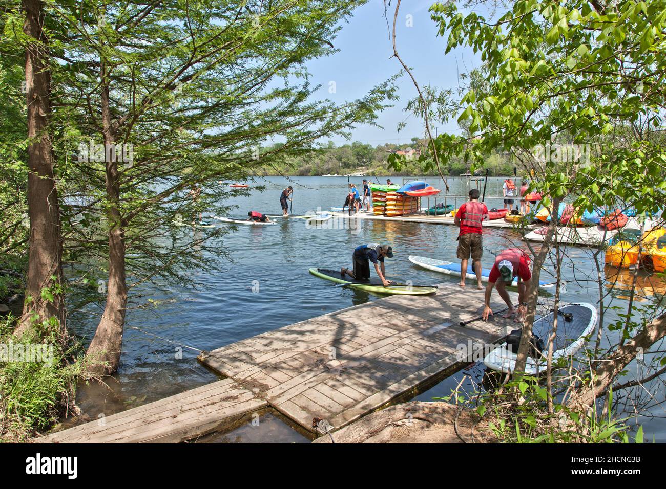 Location de paddle-board et de kayak, amateurs de sport se préparant à manipuler sur le fleuve Colorado, Lady Bird Lake, Austin, Texas. Banque D'Images