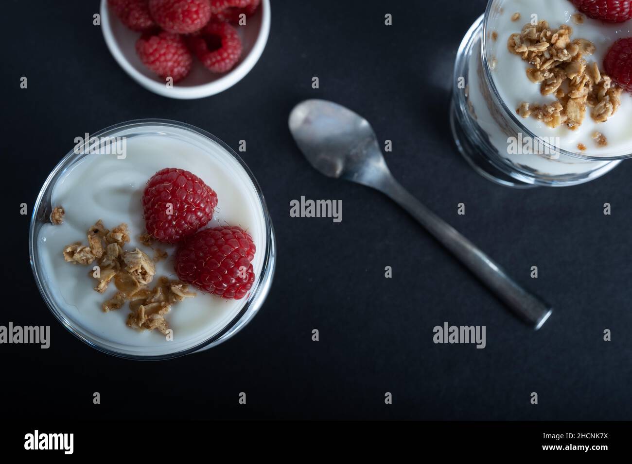 Helsinki / Finlande - 30 DÉCEMBRE 2021 : deux bols en verre de yaourt à la vanille avec granola en rouleau à la cannelle et garniture à la framboise Banque D'Images