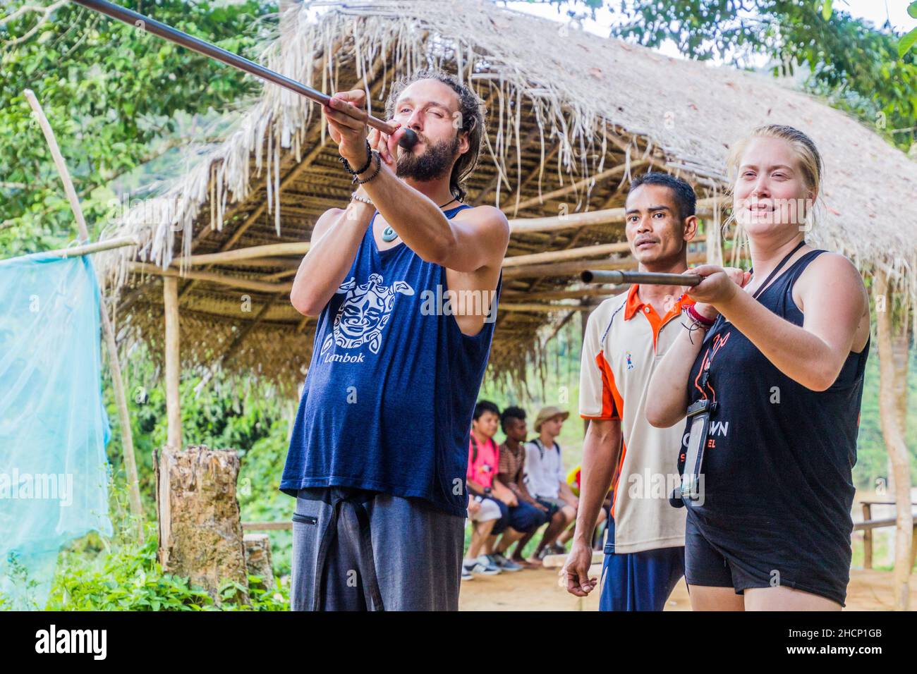 TAMAN NEGARA, MALAISIE - 17 MARS 2018: Les touristes qui essaient un coup de pipe dans un village indigène dans le parc national de Taman Negara, Malaisie Banque D'Images