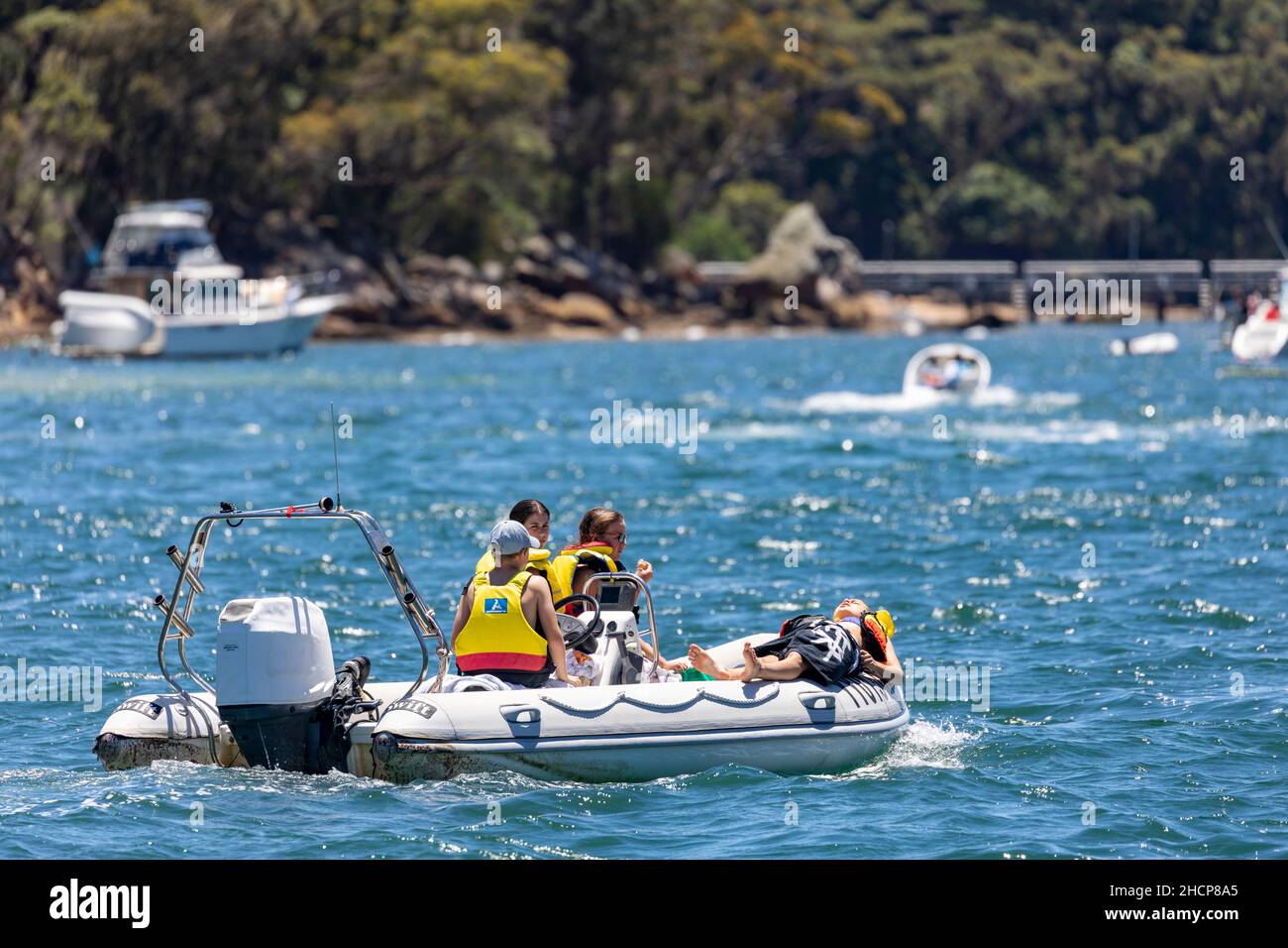 Les jeunes enfants portant un gilet de sauvetage contrôlent et exploitent un canot gonflable pneumatique en caoutchouc à Pittwater, Sydney, Australie Banque D'Images