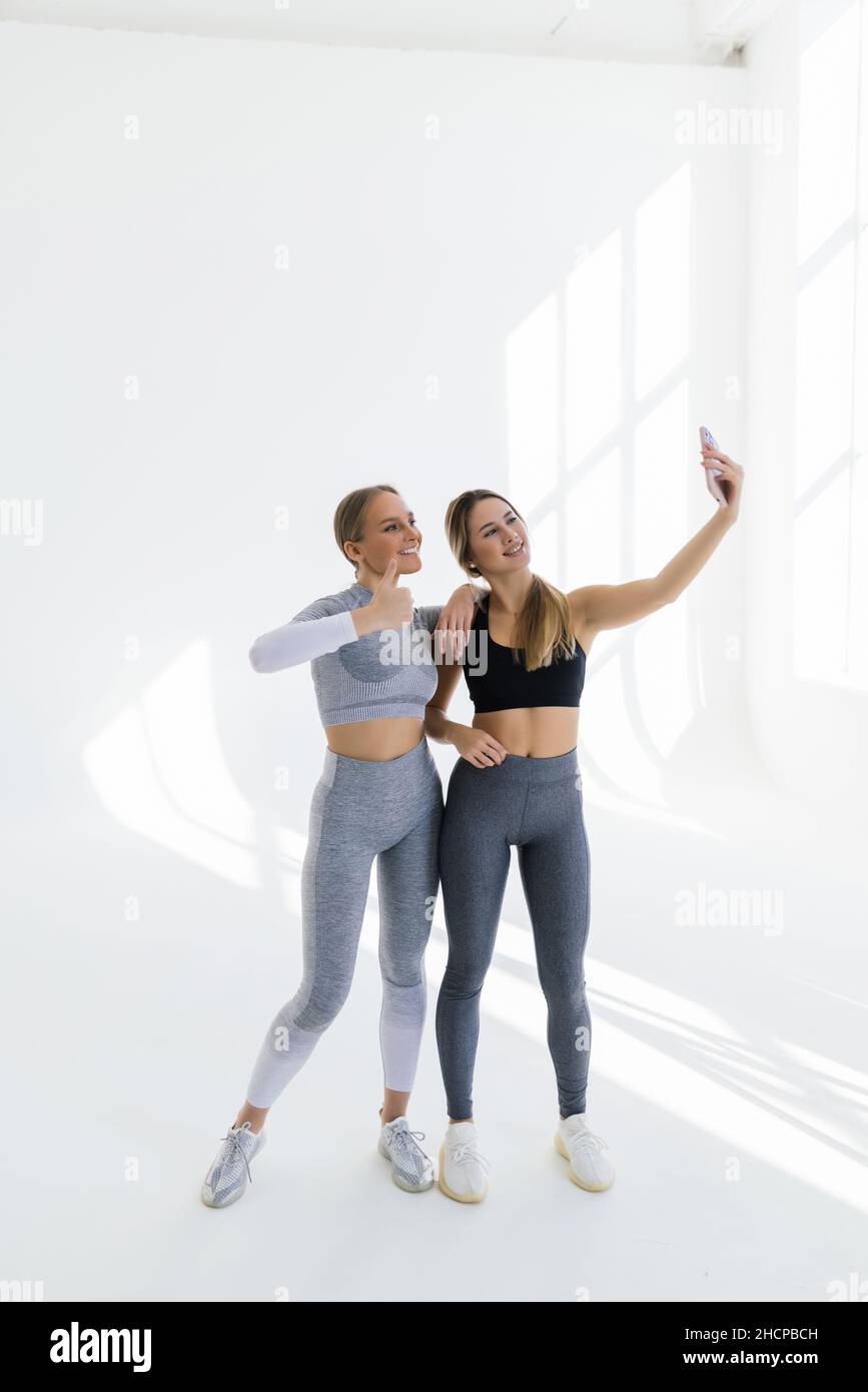 Deux femmes se rencontrent à la salle de gym, faisant le selfie photo tout en se tenant ensemble à la salle de gym Banque D'Images