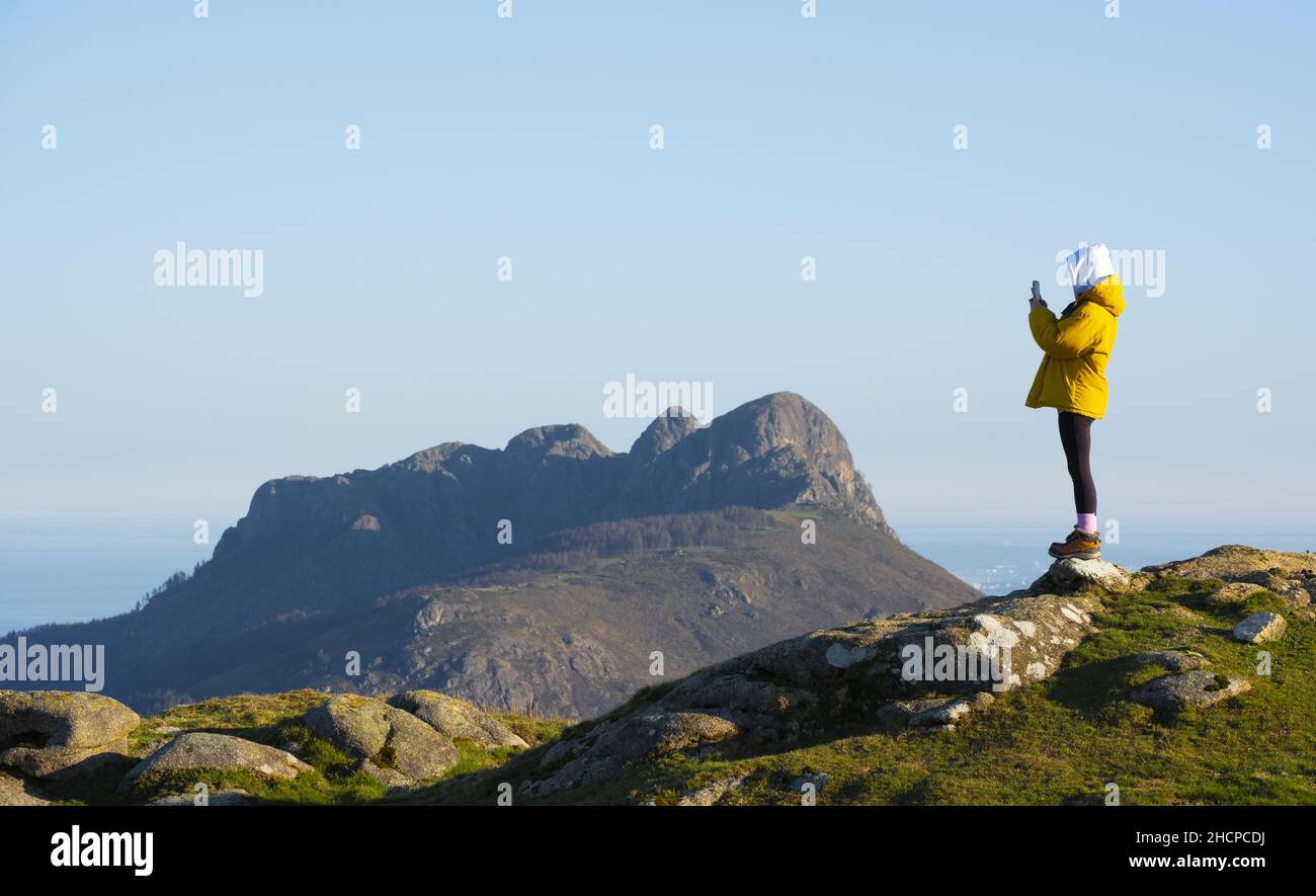 Fille avec téléphone mobile dans le parc naturel d'Aiako Harriak, Euskadi Banque D'Images