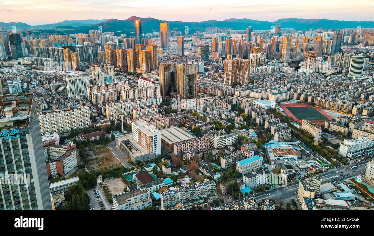KUNMING, CHINE - 30 DÉCEMBRE 2021 - la photo aérienne prise le 30 décembre 2021 montre un paysage urbain spectaculaire au coucher du soleil à Kunming, dans la province du Yunnan, en Chine. Banque D'Images