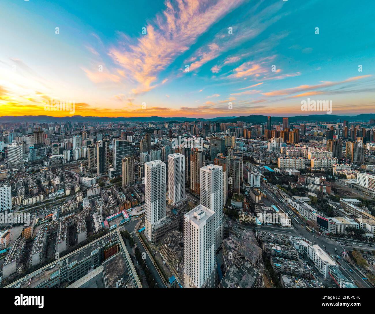 KUNMING, CHINE - 30 DÉCEMBRE 2021 - la photo aérienne prise le 30 décembre 2021 montre un paysage urbain spectaculaire au coucher du soleil à Kunming, dans la province du Yunnan, en Chine. Banque D'Images