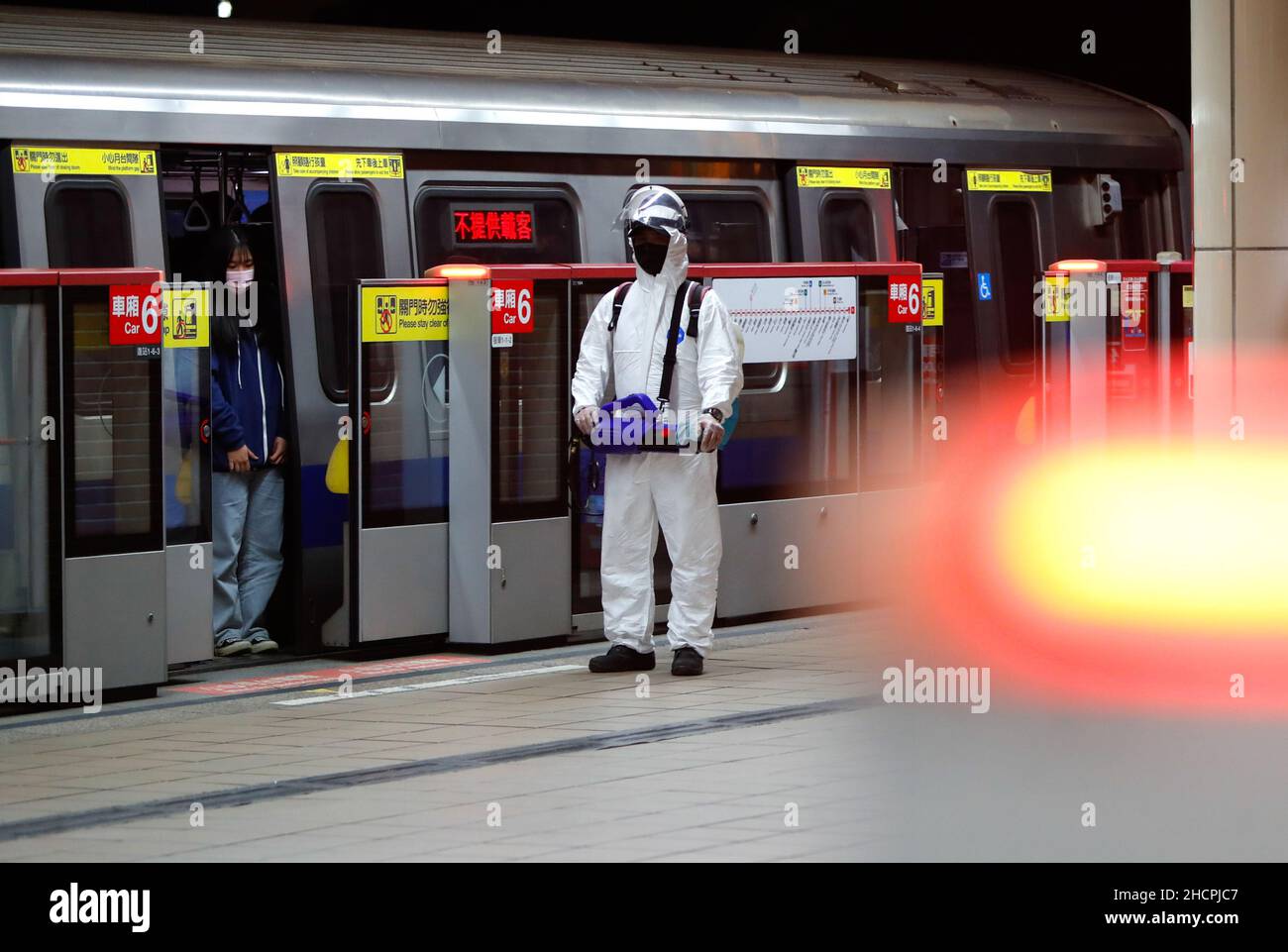 Nouveau Taipei, Nouveau Taipei, Taïwan.31st décembre 2021.Une dame (L) est vue sur un train non-en-service alors qu'un travailleur de l'EPI attend de désinfecter ses compartiments, suite au rapport du CDC de Taïwan de 41 cas importés supplémentaires et de 1 infection Omicron.Le nombre d'infections domestiques à Taiwan est resté faible, mais il y a eu un nombre croissant de cas importés en raison de l'ouverture des frontières pour que les nationaux reviennent pour la réunification les jours fériés et le nouvel an lunaire.(Image de crédit : © Daniel Cing Shou-Yi/ZUMA Press Wire) Banque D'Images