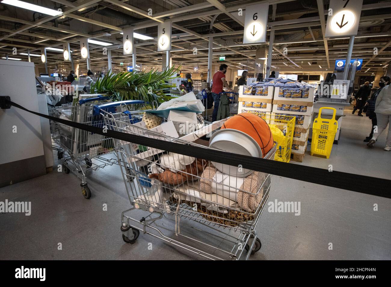 Un chariot de shoppers se trouve abandonné plein d'achats indésirables près des rangées de caisses dans un IKEA dans le sud de Londres, Angleterre, Royaume-Uni Banque D'Images