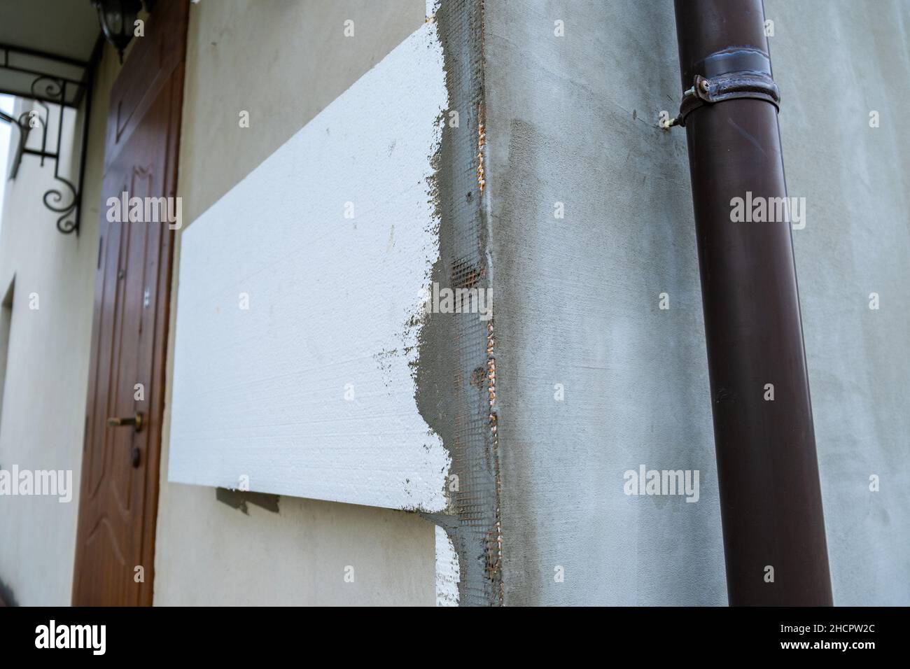 Installation de feuilles d'isolation en mousse de polystyrène sur le mur de la façade de la maison pour la protection thermique. Banque D'Images