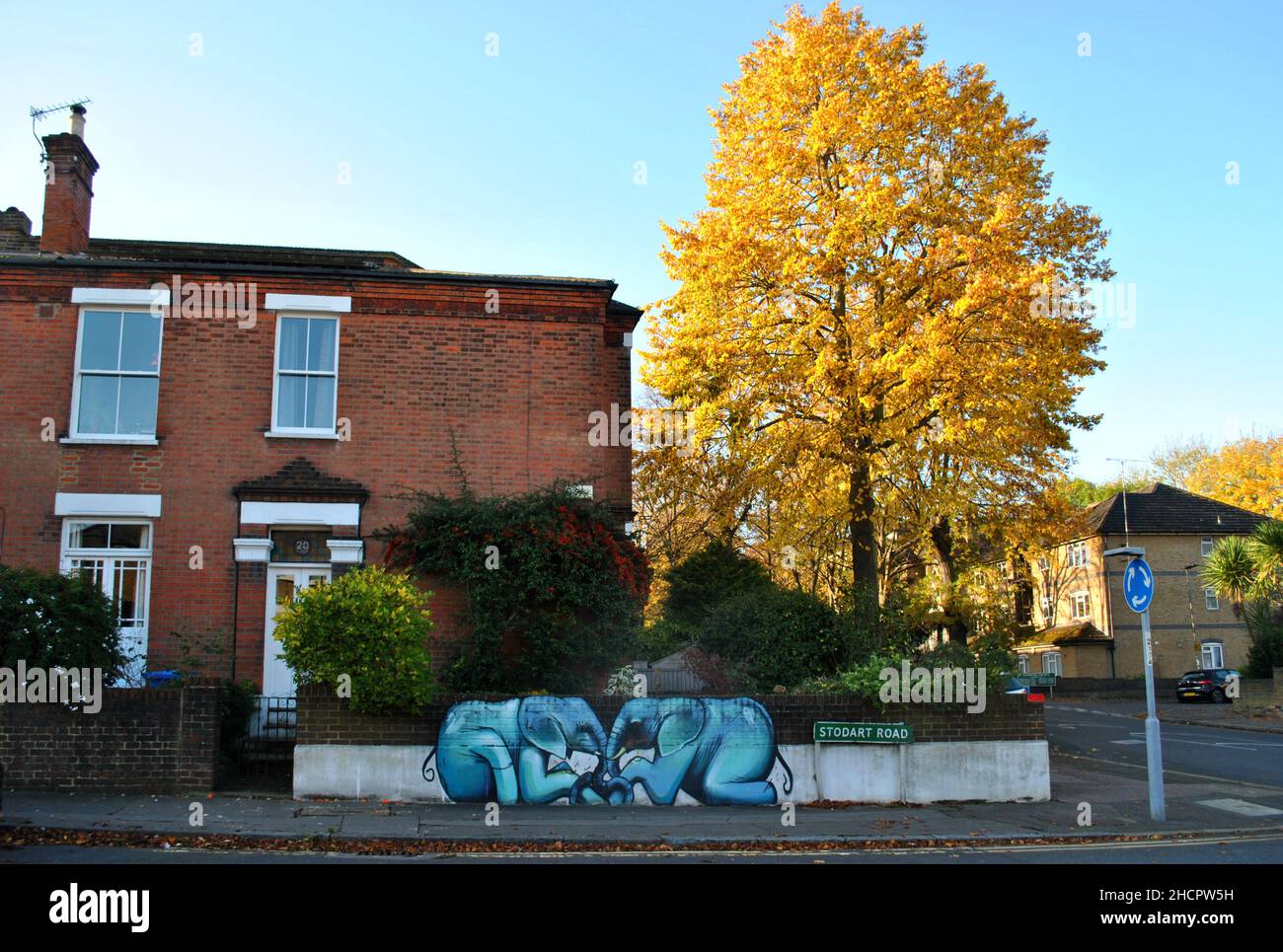Une œuvre d'art Baby Elephants sur la toile de fond d'une maison de banlieue et d'un arbre d'automne jaune, à Penge, dans le sud-est de Londres. Banque D'Images