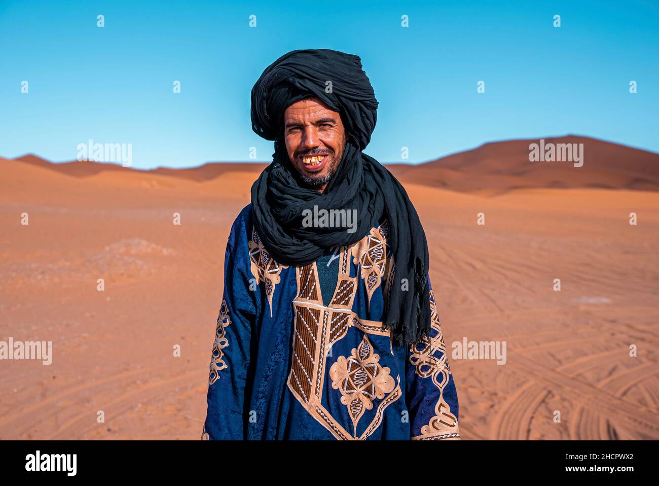 L'homme bédouin porte des vêtements traditionnels tout en se tenant dans le désert contre le ciel clair Banque D'Images