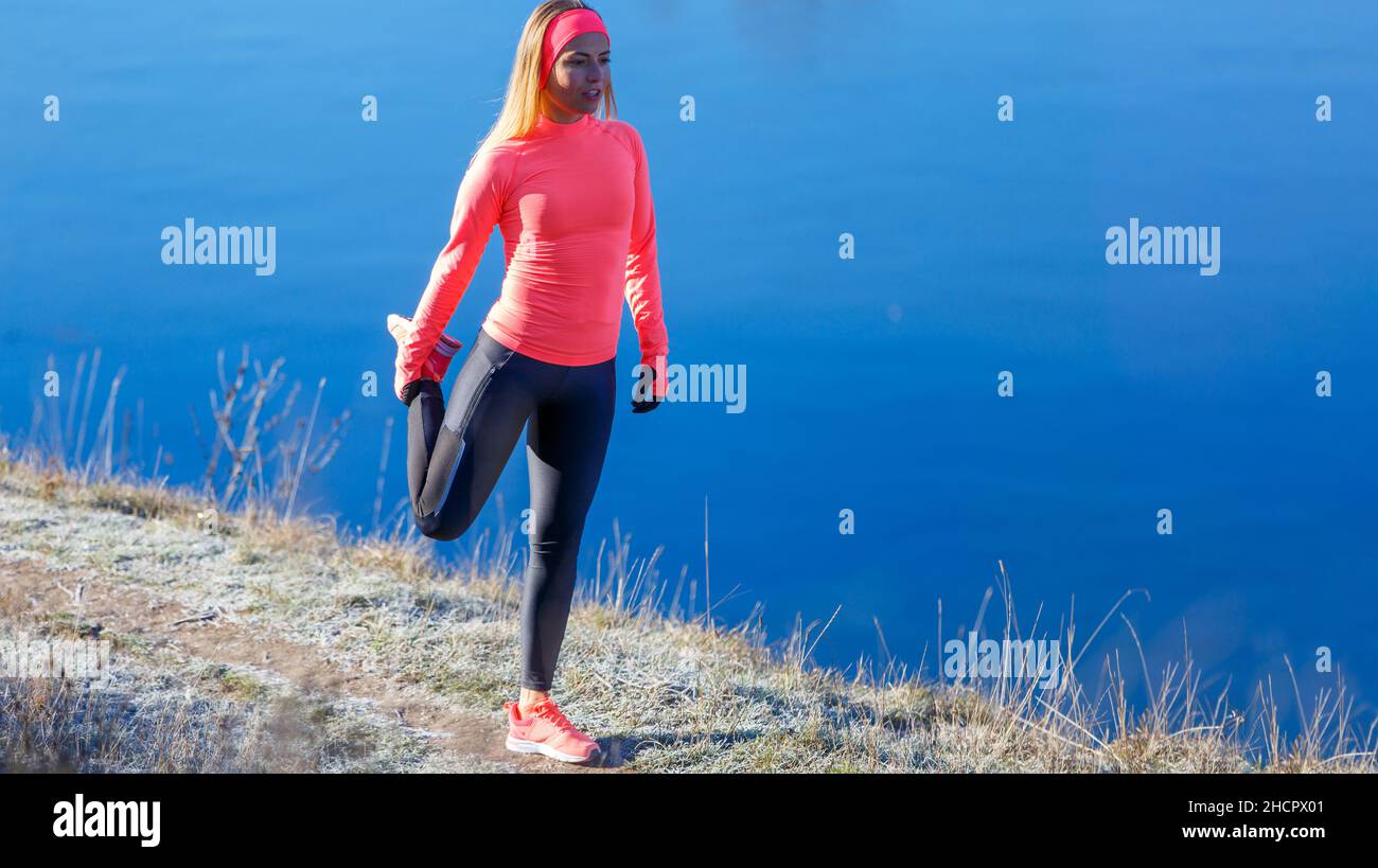 Jeune femme sportive qui s'étire les jambes le matin glacial Banque D'Images