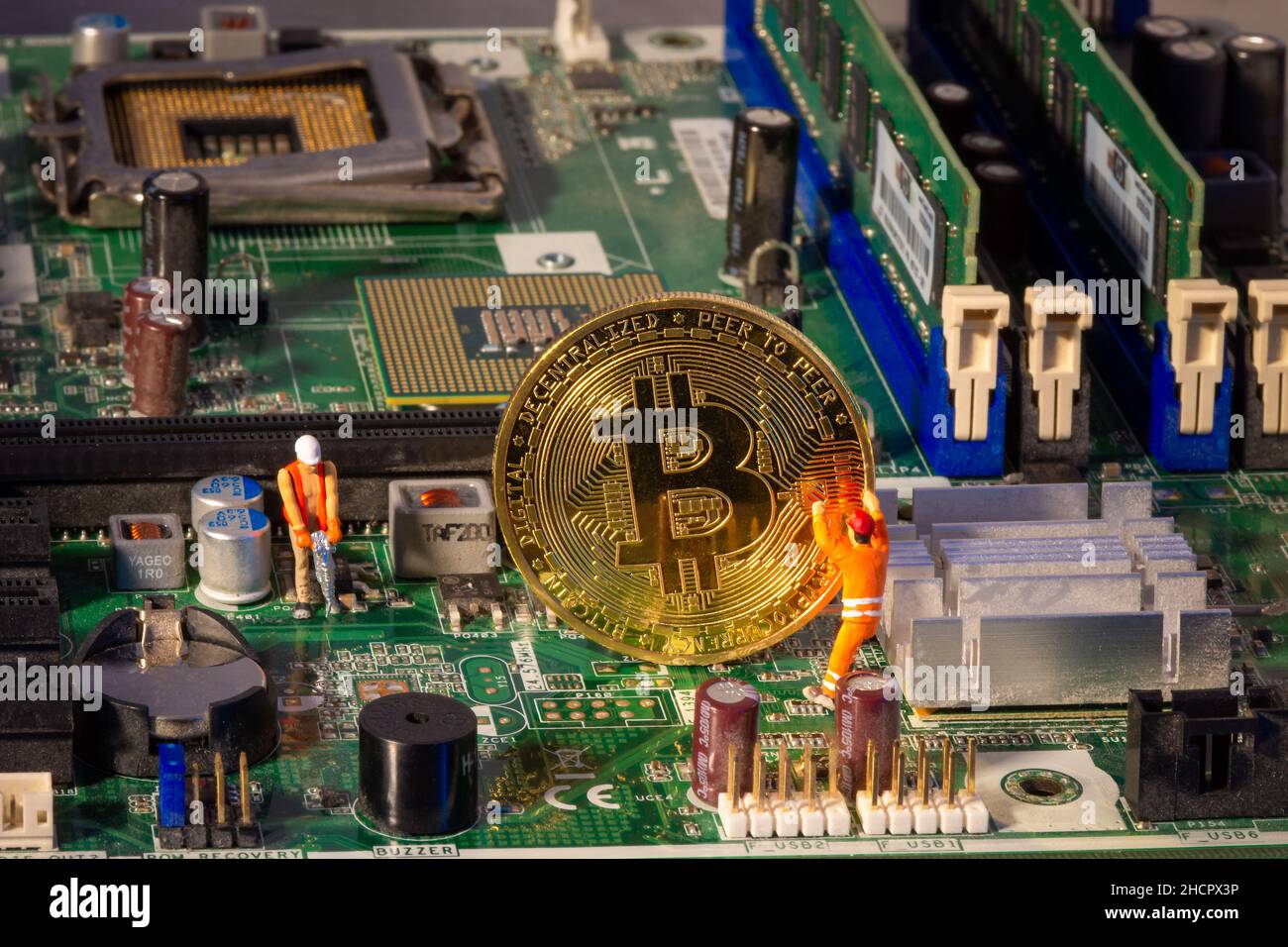 Extraction de bitcoin à l'intérieur d'un ordinateur.Deux petits mineurs de Bitcoin figurines d'extraction de précieuses crypto-monnaies numériques extraites électroniquement de la carte mère Banque D'Images
