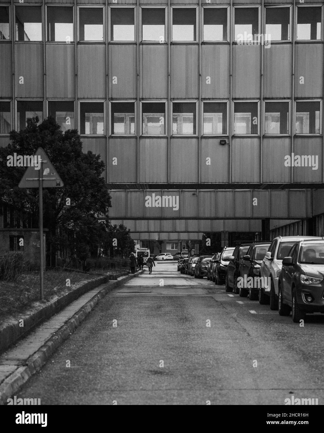 Photo en noir et blanc d'une rue avec des parkings et un bâtiment résidentiel Banque D'Images