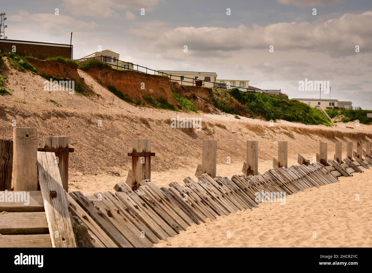 Maisons et érosion côtière avec sable à la plage et falaises à Bacton, Norfolk, Royaume-Uni Banque D'Images