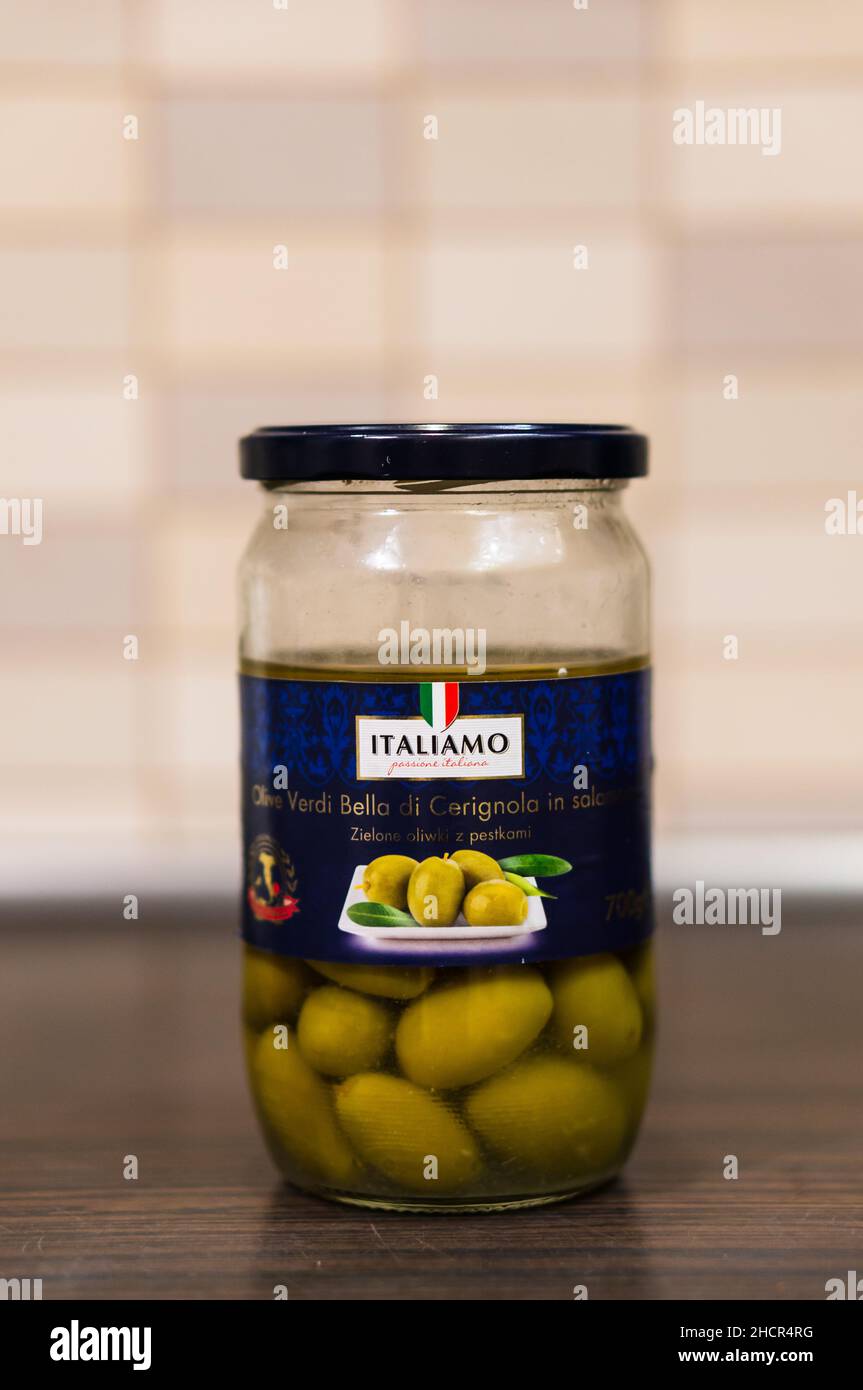 Gros plan des olives vertes de marque Italiamo dans de l'huile dans un pot ouvert en verre Banque D'Images