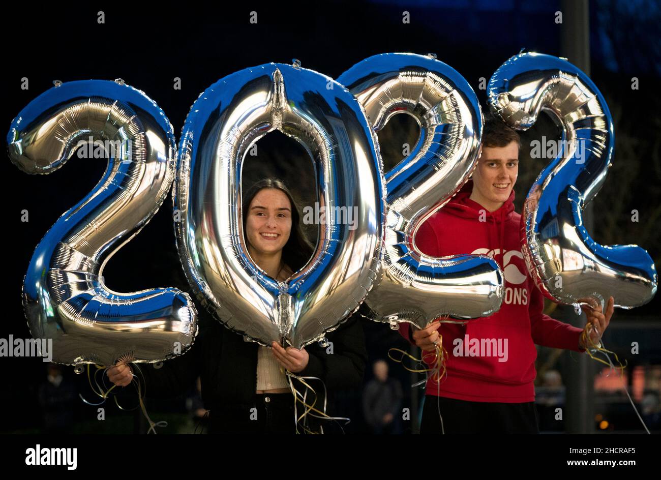 Caitlin Scott (à gauche) de Glasgow et Harry McAuley d'Aberdeen posent sur Princes Street d'Édimbourg avec des ballons qu'ils ont achetés pour leur fête de la Saint-Sylvestre.Date de la photo: Vendredi 31 décembre 2021. Banque D'Images