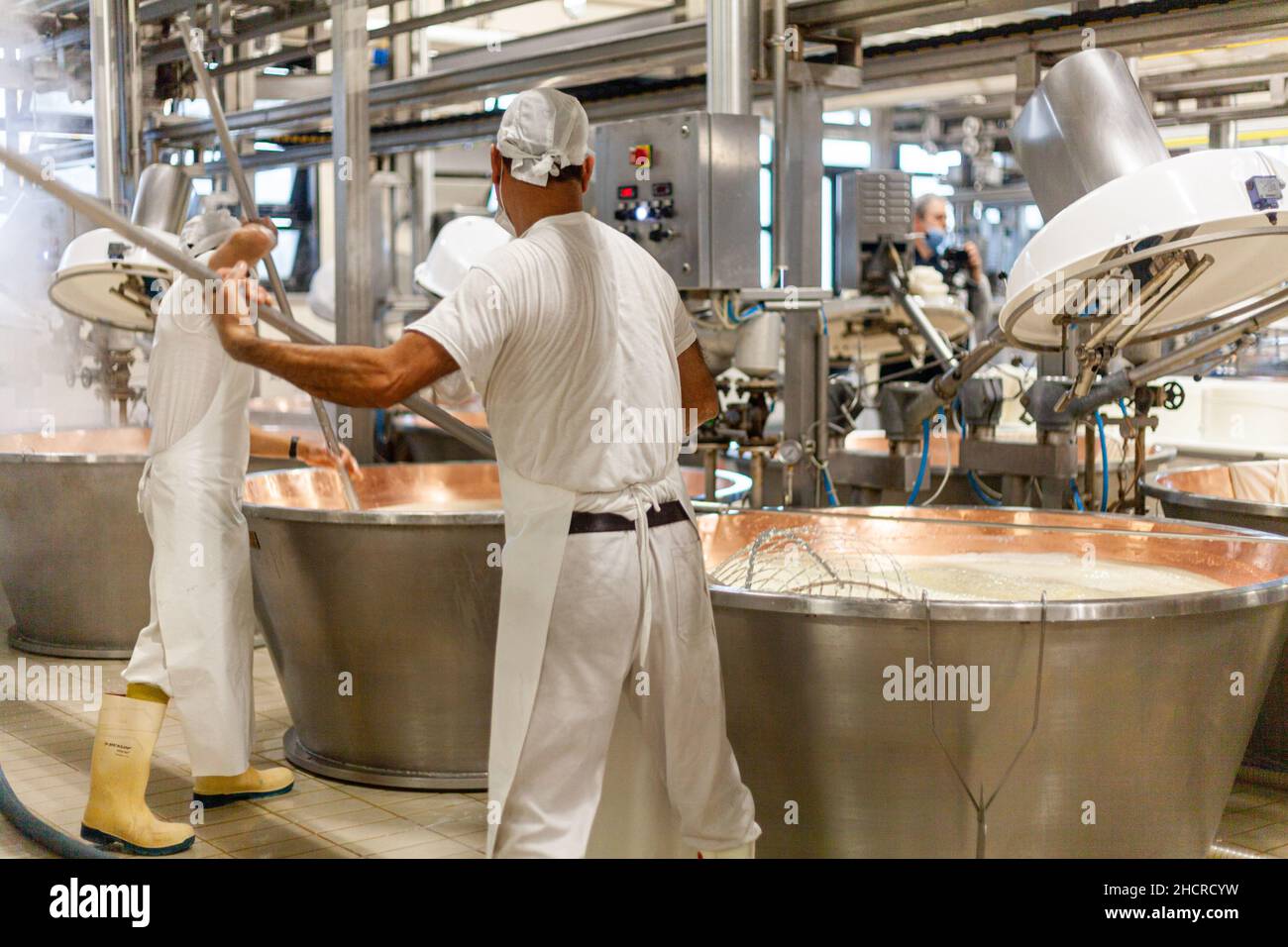 Fromagère laitière de fabrication de fromage, Parme 2064 roues de fabrication, et ouvriers avec des uniformes blancs Banque D'Images