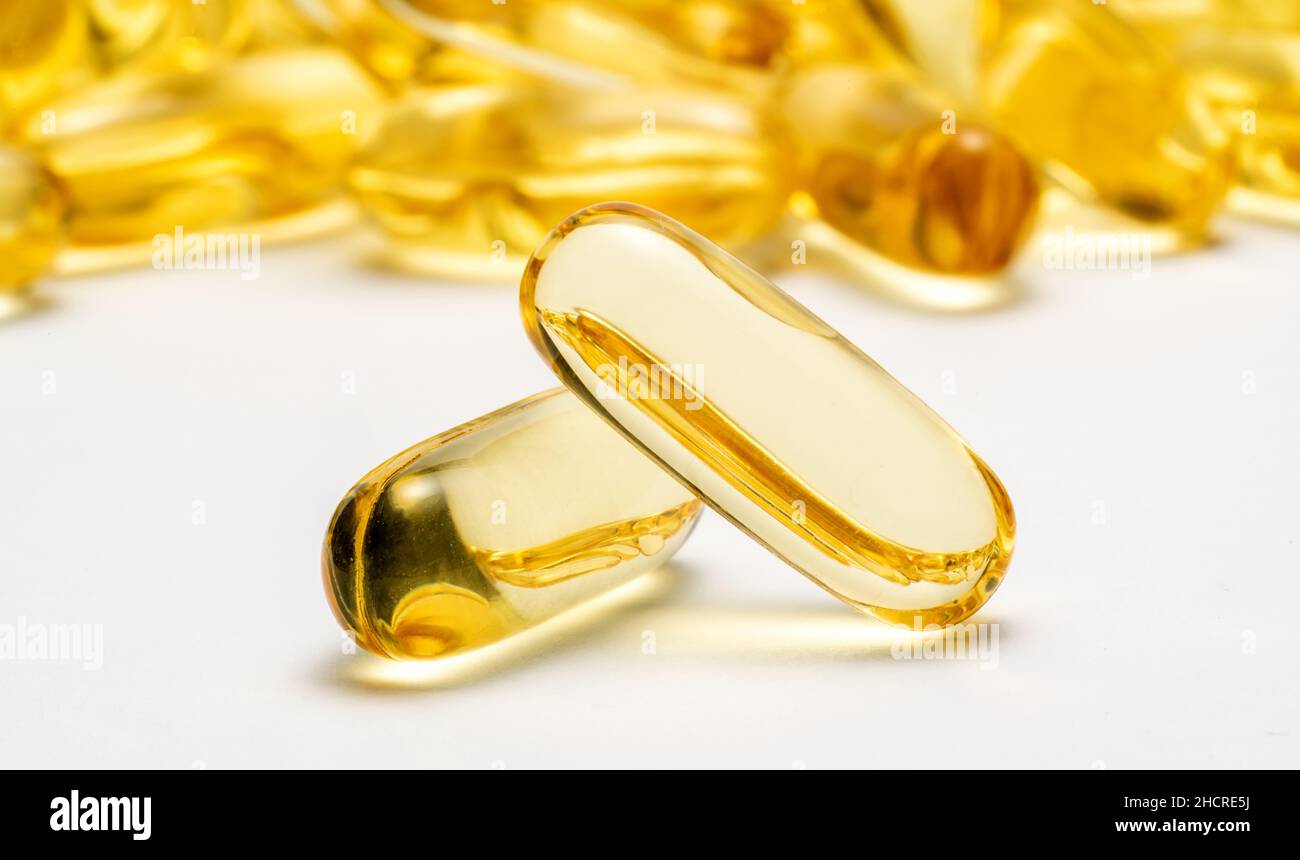 Deux capsules Omega 3 et beaucoup d'autres capsules sur fond flou.Image de concept de soins de santé Banque D'Images