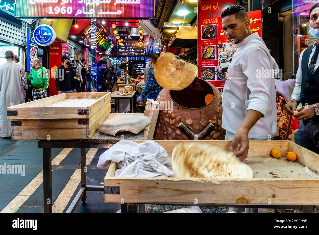 Un jeune homme mettant Un pain plat traditionnel dans un four, Abuzaghleh Restaurant, Downtown Amman, Amman, Jordanie. Banque D'Images