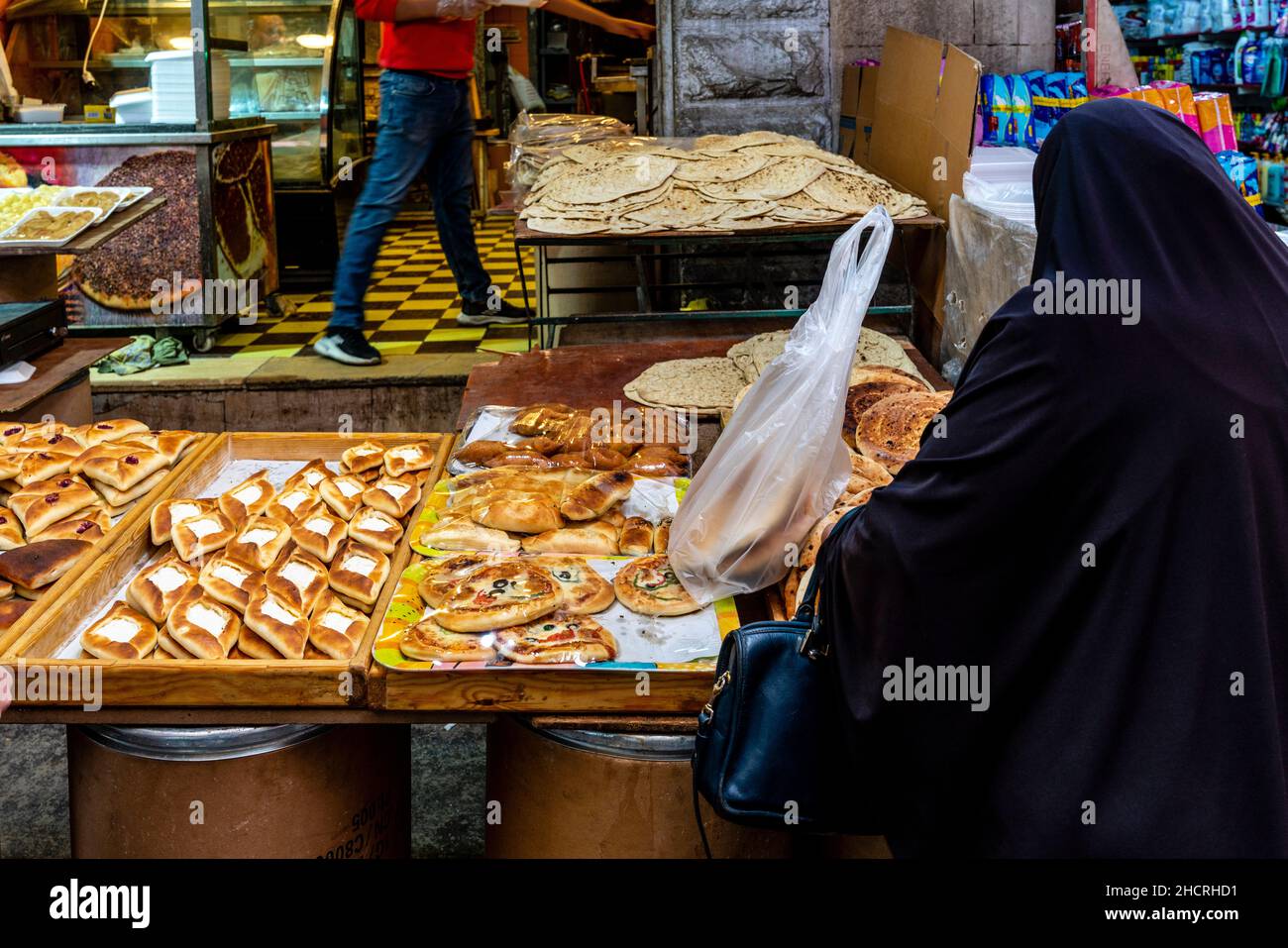 Une femme achète des gâteaux et des pâtisseries à Un Stall dans le souk, Amman, Jordanie. Banque D'Images