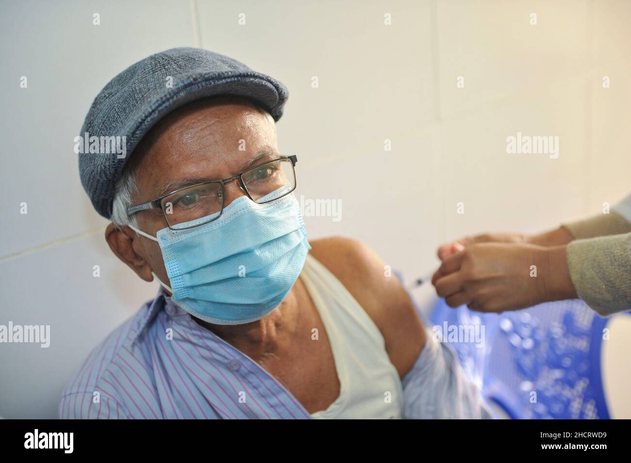 Un aîné reçoit le vaccin de rappel Pfizer contre la maladie de Covid-19 au centre de vaccination de l'hôpital et du collège médical M A G Osmani pendant la campagne de vaccination de rappel COVID-19 afin d'intensifier ses efforts pour contenir la propagation du virus mortel.Le 30 décembre 2021 à Sylhet, Bangladesh.(Photo de MD Rafayat Haque Khan/Eyepix Group) Banque D'Images