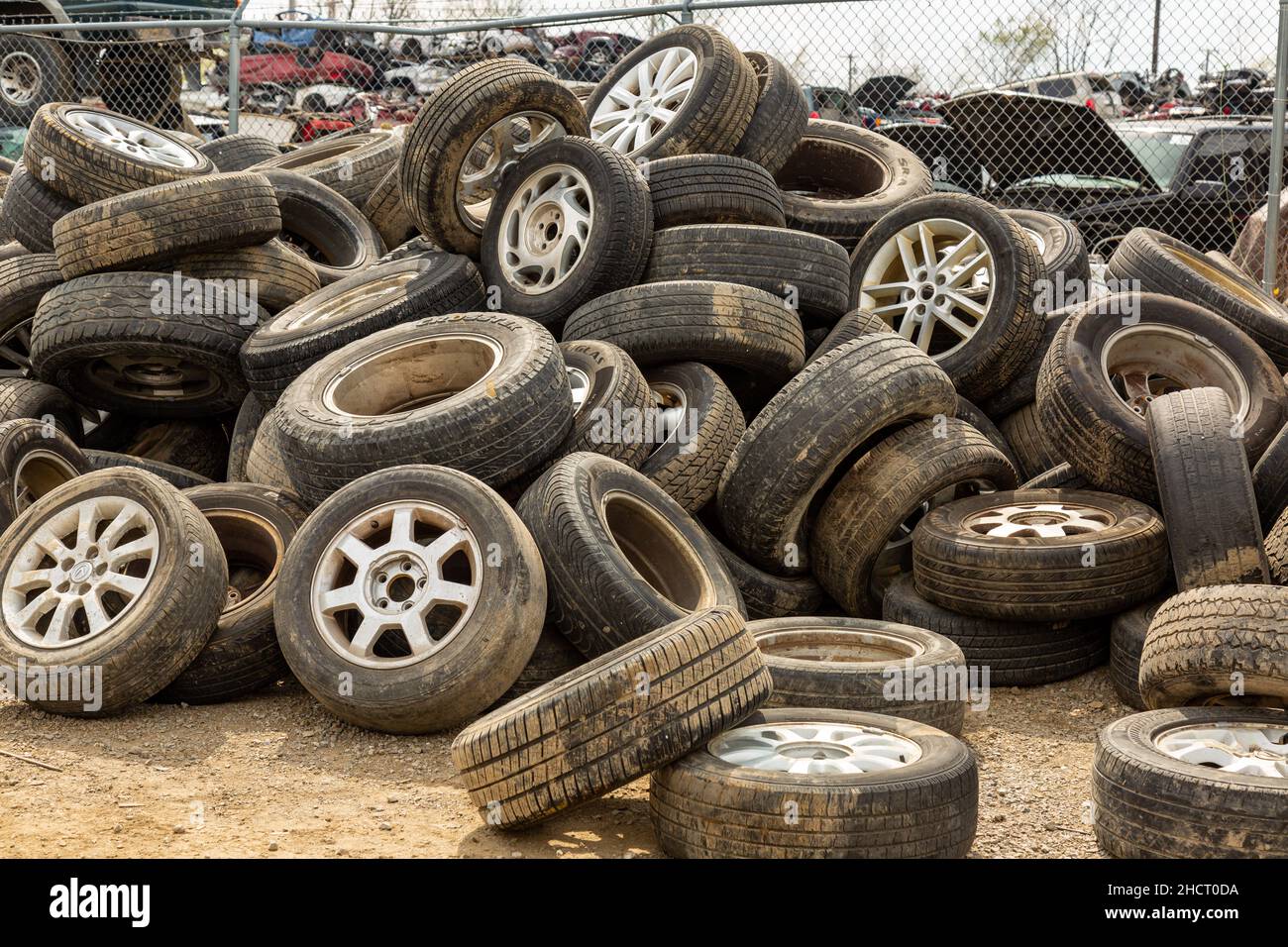 Une pile de pneus et de roues en caoutchouc désutilisés au chantier de récupération de voiture Pick Your part à fort Wayne, Indiana, États-Unis. Banque D'Images