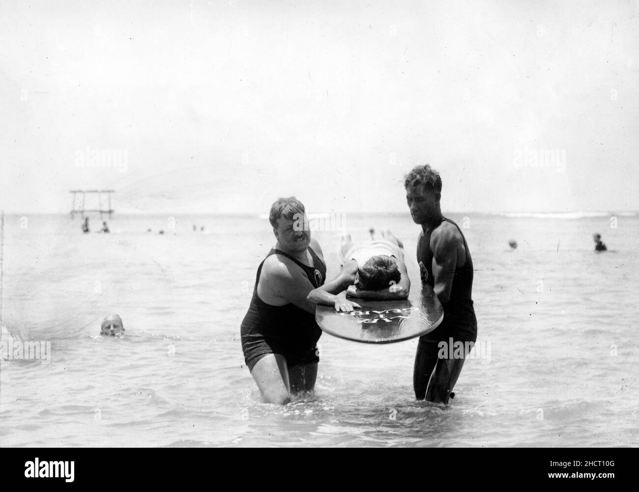 En eau peu profonde, le surf peut être utilisé comme civière pour transporter le patient à la plage - instruction de sauvetage, vers 1925 Banque D'Images