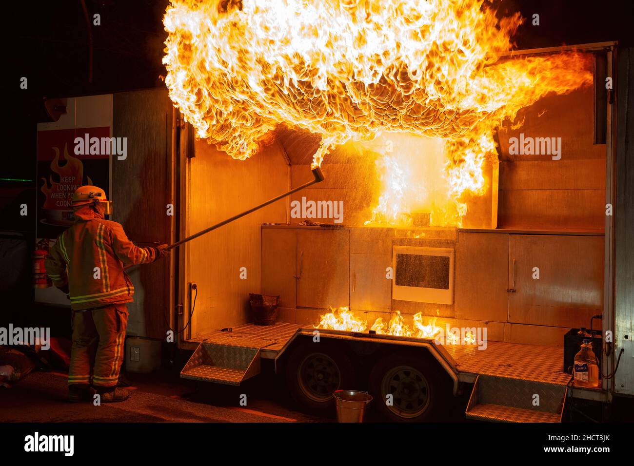 Un pompier crée une énorme boule de feu lors d'une démonstration de sécurité, illustrant ce qui se passe si de l'eau est jetée sur un feu d'huile de cuisine Banque D'Images