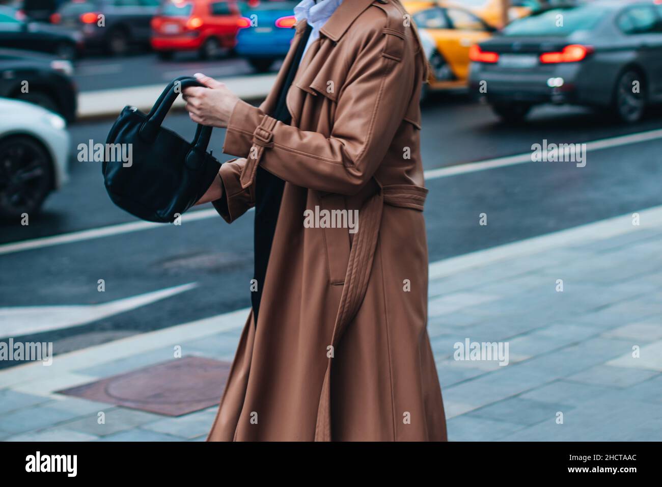 Tenue automnale tendance pour femme.Femme élégante marchant dans un manteau  brun avec sac à main noir à l'extérieur.Des vêtements modernes et tendance.Mode  Street style Photo Stock - Alamy