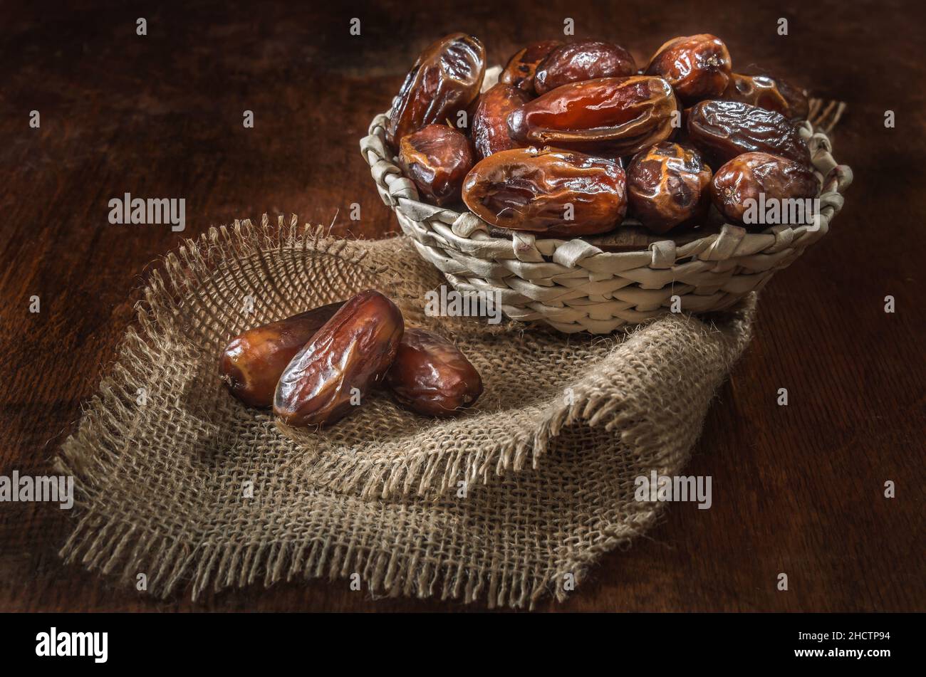 dates mûres dans un panier sur fond de bois sombre Banque D'Images