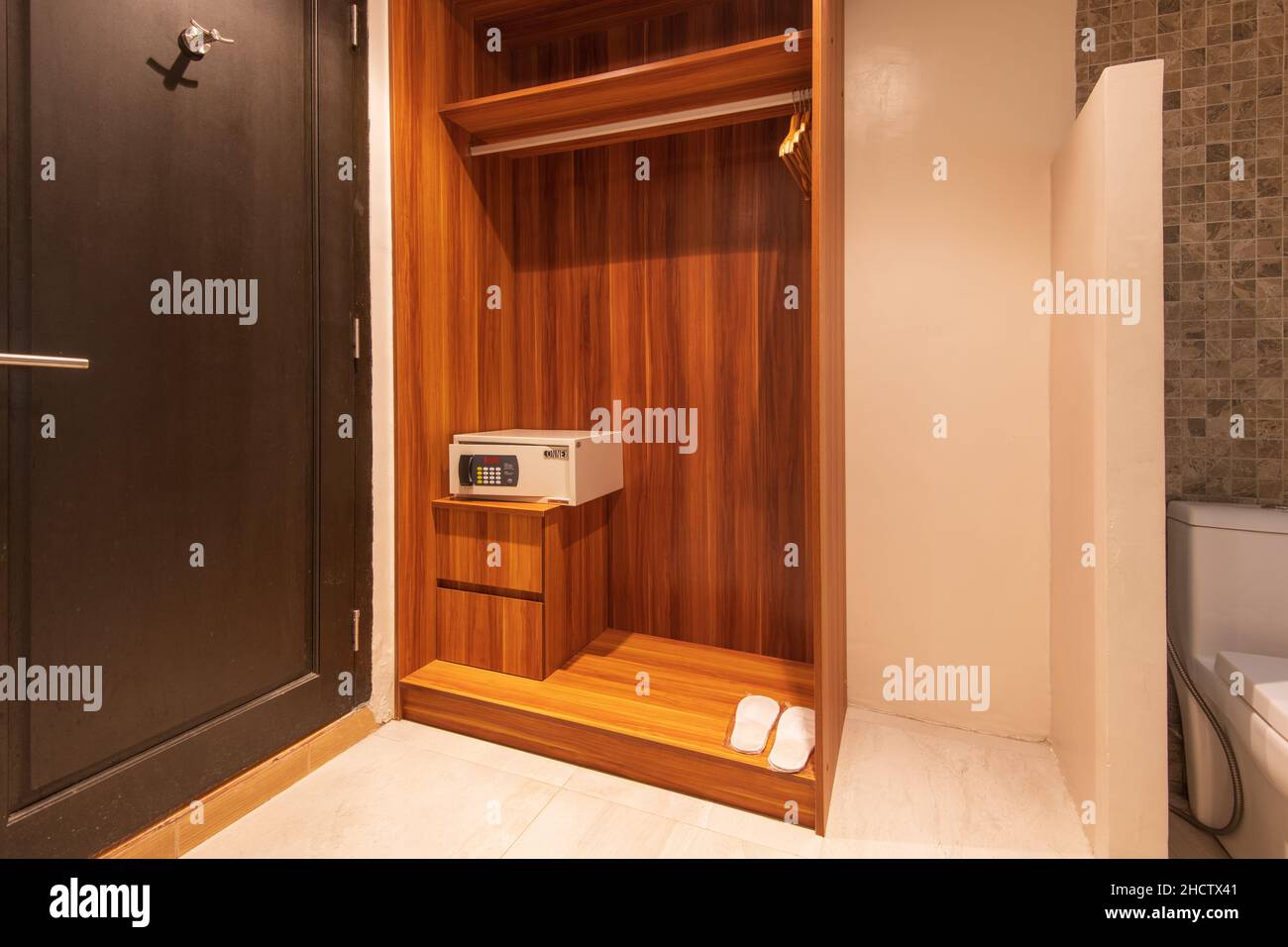 Vue verticale d'un coffre-fort dans une armoire en bois à côté d'une porte marron foncé Banque D'Images