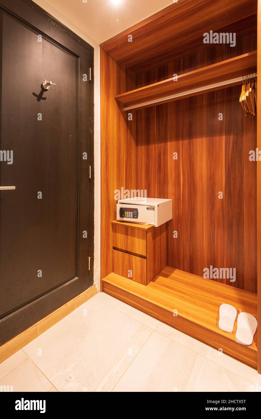 Vue verticale d'un coffre-fort dans une armoire en bois à côté d'une porte marron foncé Banque D'Images