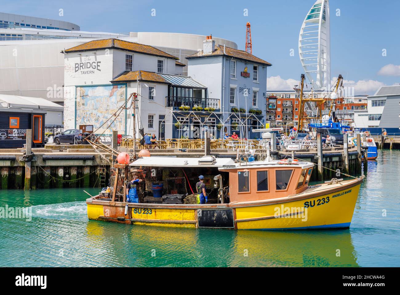 Petit bateau de pêche jaune près de la Taverne de Fullers Bridge, Camber Quay dans le port de Portsmouth, Hampshire, côte sud de l'Angleterre Banque D'Images