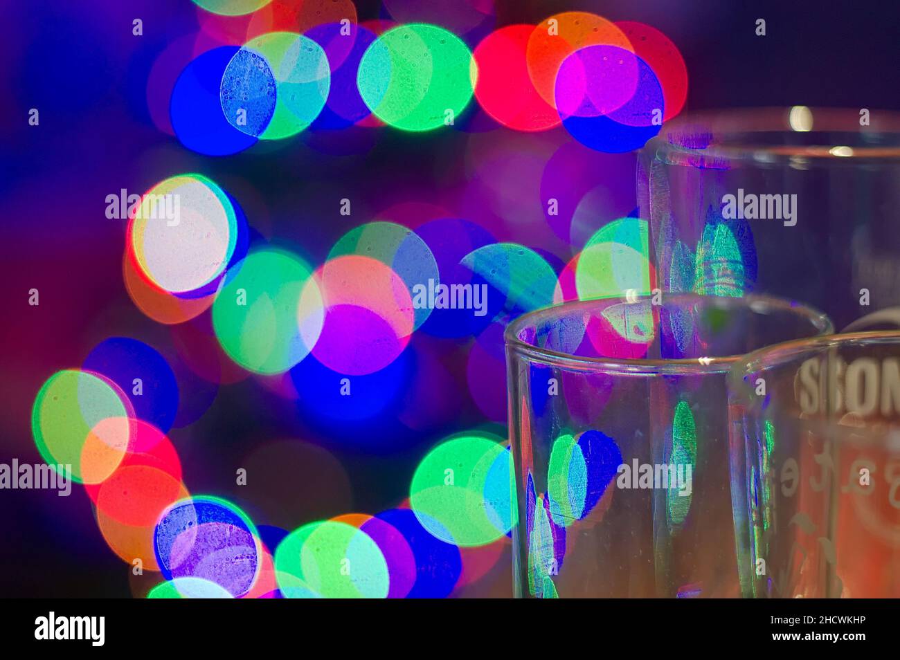 Videz les verres à bière avec des lumières colorées défocacées en arrière-plan Banque D'Images