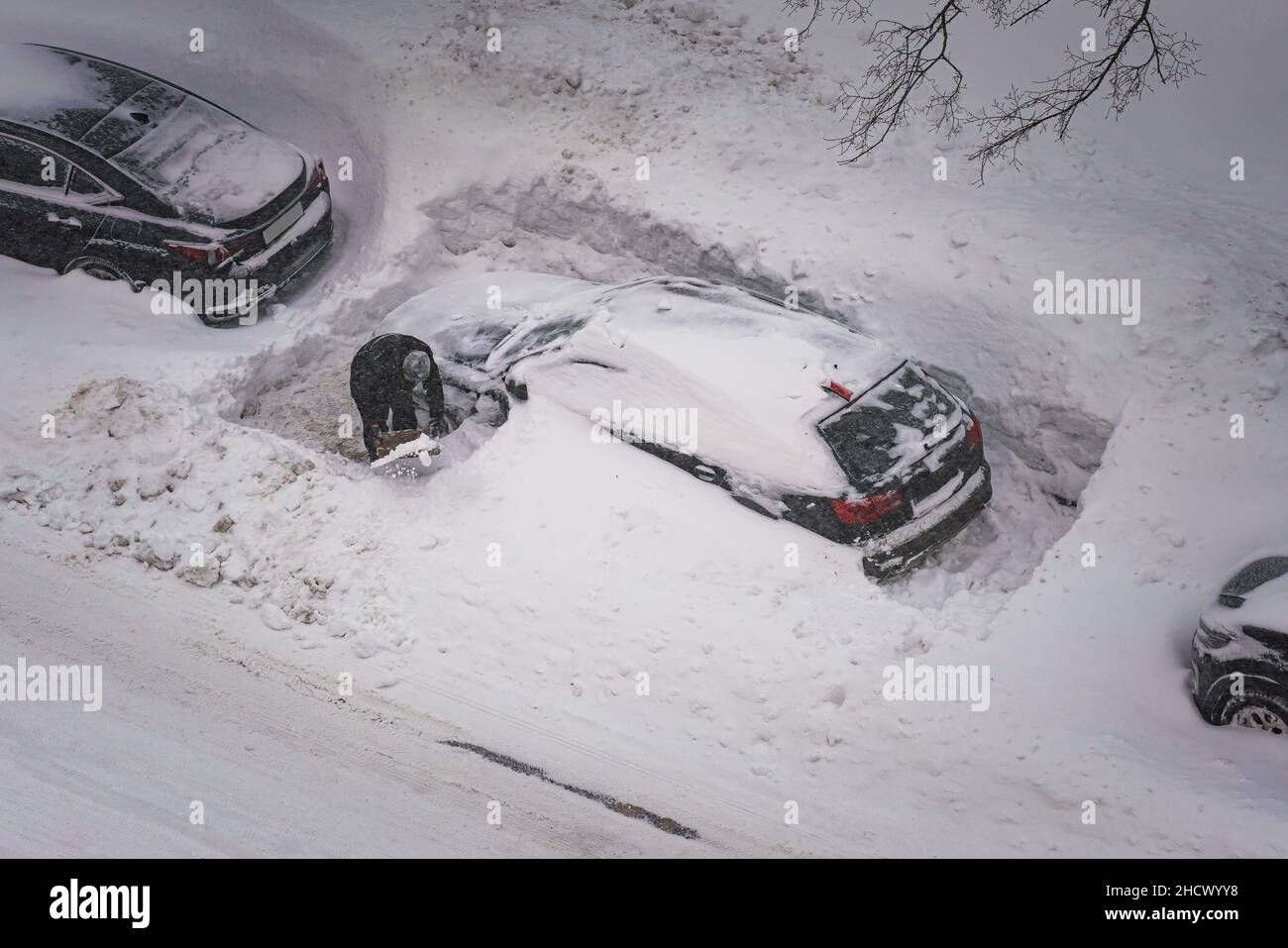 Excavation (libération) de la voiture avec des moyens improvisés après une forte chute de neige (nettoyage manuel de la neige près de la voiture après une forte chute de neige) Banque D'Images