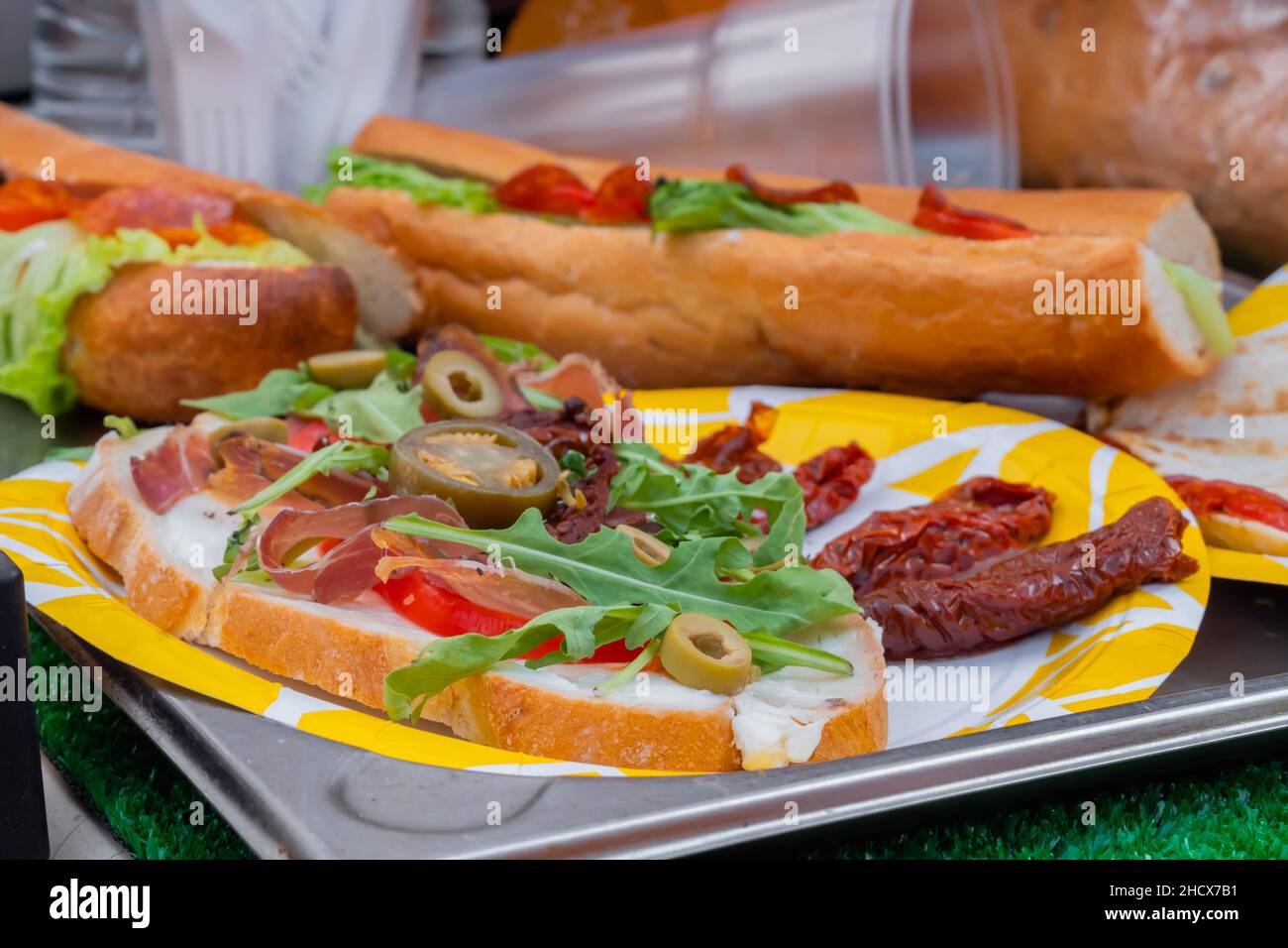 Sandwich avec arugula, jambon, fromage, jalapeno, tomates séchées, salami - gros plan Banque D'Images Sandwich avec arugula, jambon, fromage, jalapeno, tomates séchées, salami - gros plan Banque D'Images