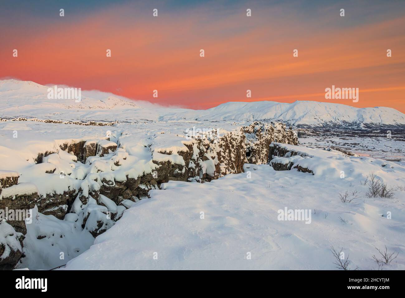 L'aube dans le parc national de Thingvellir apporte le ciel rouge sur une neige plus blanche. Banque D'Images