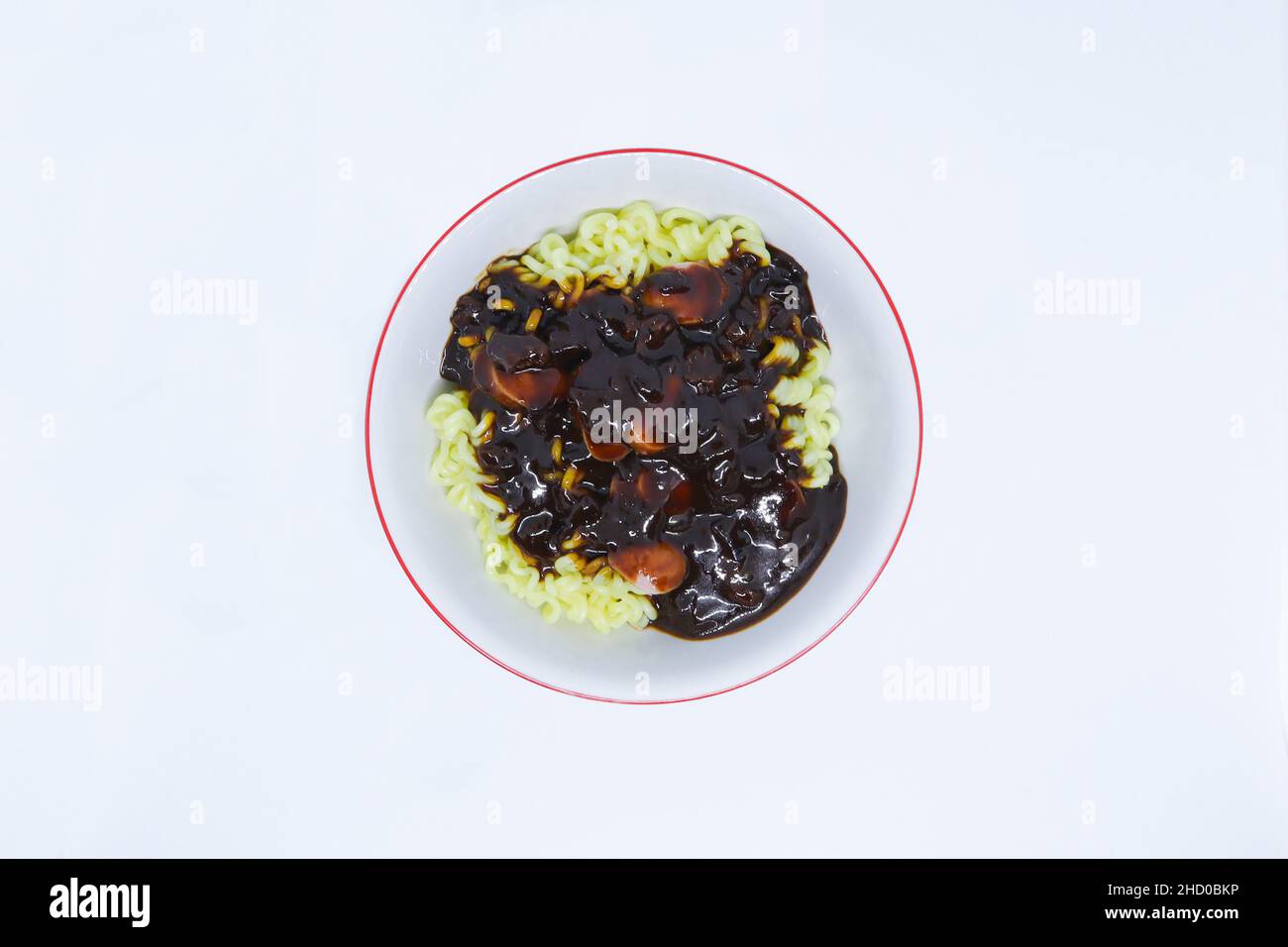 Une prise de vue à plat de délicieux nouilles coréennes nommée Jjajangmyeon avec des saucisses comme une garniture dans le fond blanc Banque D'Images