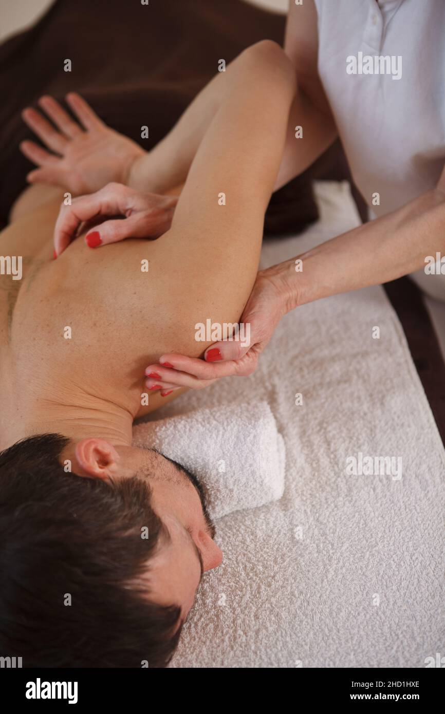 Vue de dessus vue verticale d'un masseur massant l'épaule d'un homme Banque D'Images