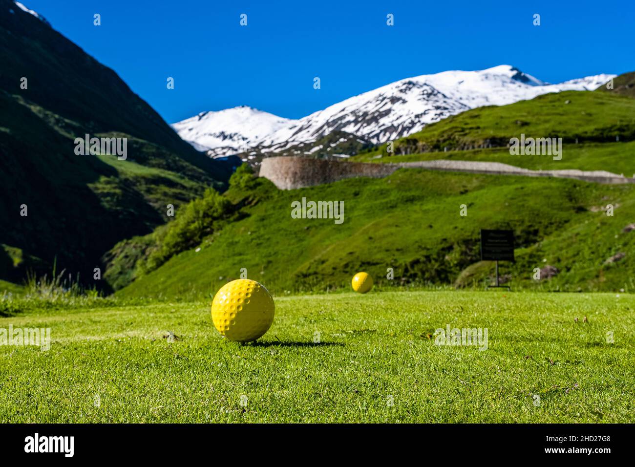 Un parcours de golf, situé sur la route du col de Furka, des montagnes enneigées autour du col de Furka au loin. Banque D'Images