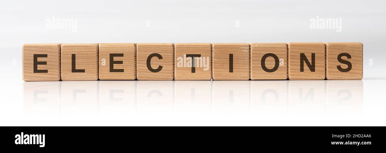 Élections Mot écrit en cubes de bois sur fond blanc brillant avec reflet Banque D'Images