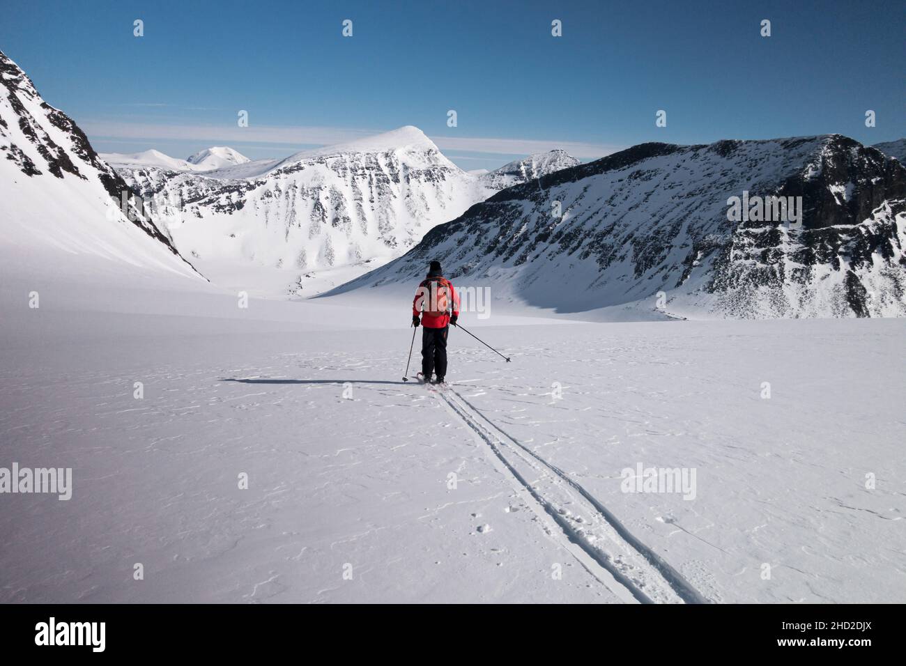 Laponie, Suède - 18 avril 2019 : skieur unique en position éloignée en Suède Laponie se préparant à skier dans la vallée avec de la neige non suivie sur un Bluebird WE Banque D'Images