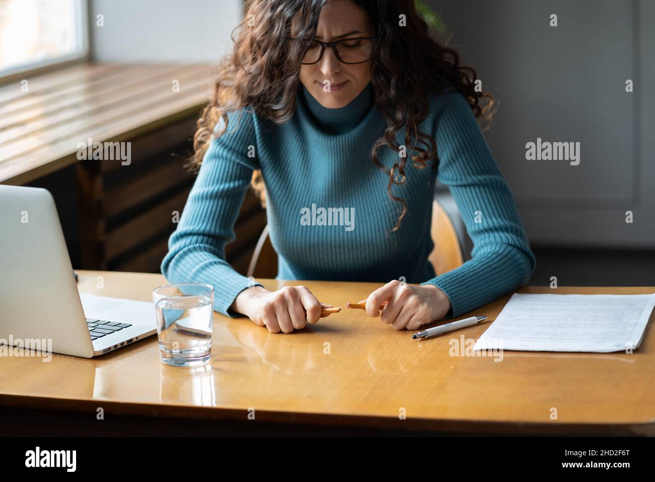 Jeune femme stressée sur le lieu de travail avec un crayon cassé, inquiète femme employé se sentant nerveux Banque D'Images