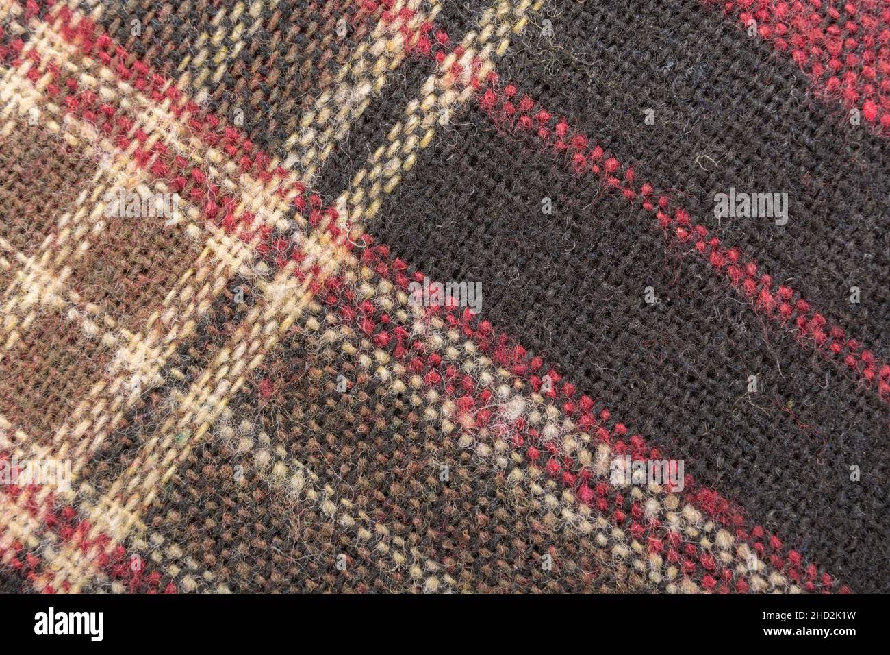 Gros plan macro sur un tissu en flanelle à carreaux rouges, avec motif de fil de trame et de gauchissement et coutures blanches.Ligne cousue, lignes de points Banque D'Images