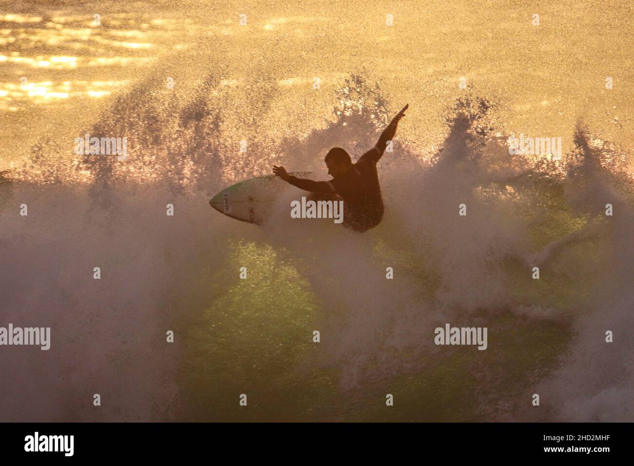 Surfer sur une vague bleue par beau temps Banque D'Images
