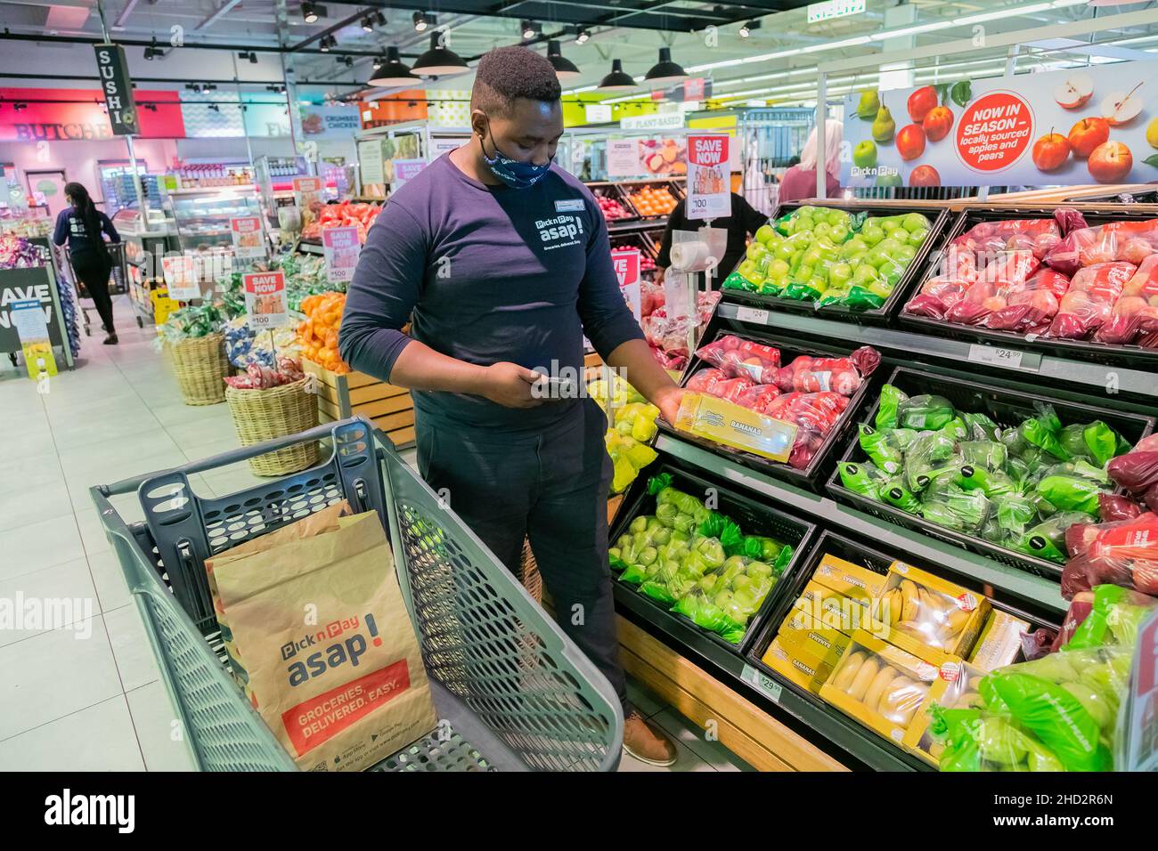 Cape Town, Afrique du Sud - 9 septembre 2021 : un membre du personnel cueille des produits à partir de l'étagère pour un service de livraison express à domicile Banque D'Images