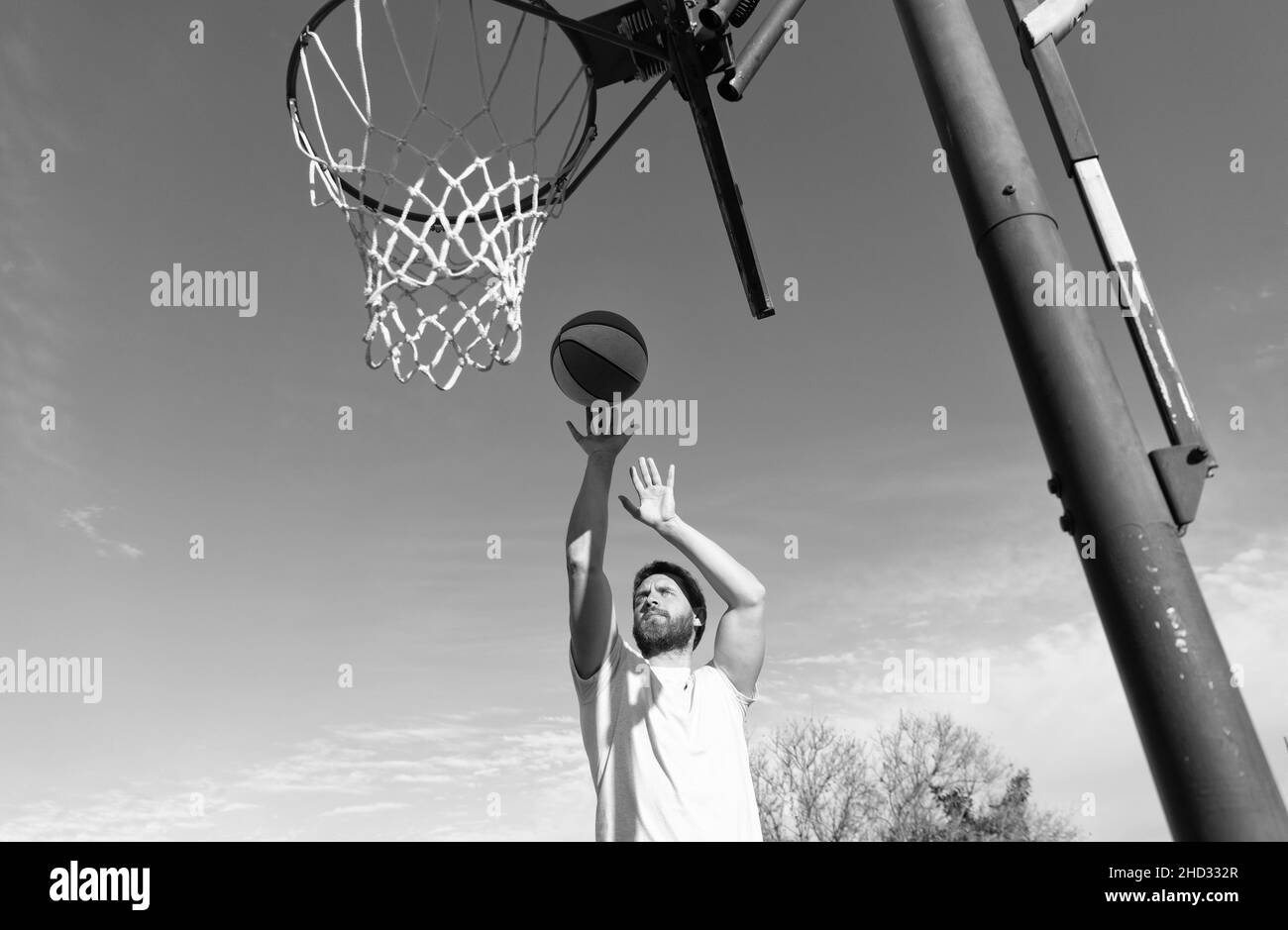 homme lancer le ballon dans le panier jouer au basket-ball dans le terrain de jeu de sport d'été, activité sportive Banque D'Images