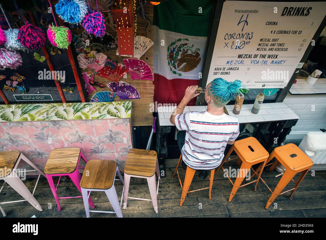 Homme avec des cheveux bleus Profitez d'un verre à Pop Brixton, pop up container bars et restaurants à Brixton, Londres, Royaume-Uni Banque D'Images